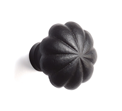 Svart knopp i smidesstil med veckad design och cirkulär bas.